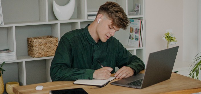 Man in Green Long Sleeve Shirt Sitting on Writing