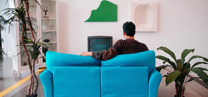 man enjoying the television at sofa
