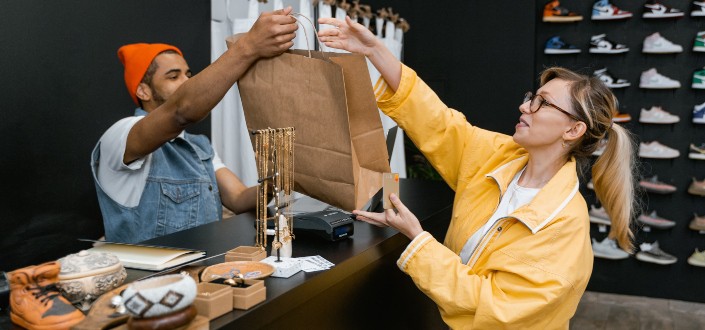 Man Handing Shopping Bag to a Customer