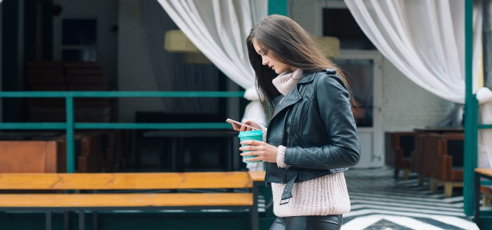 Girl walking on the street while texting