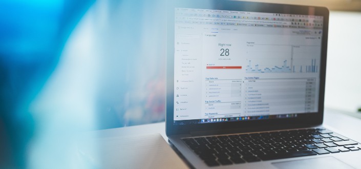 A laptop on top of the table displays graphs