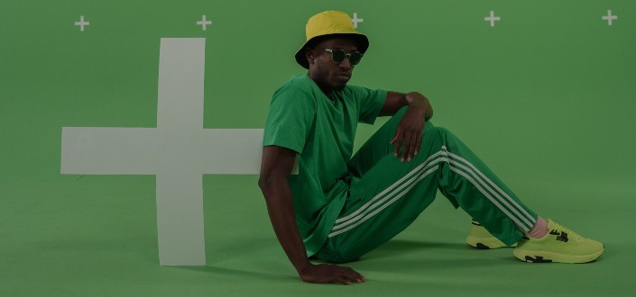Man wearing green Sitting on Green Surface
