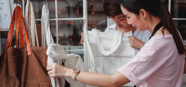 women choosing cotton bags in fashion boutique