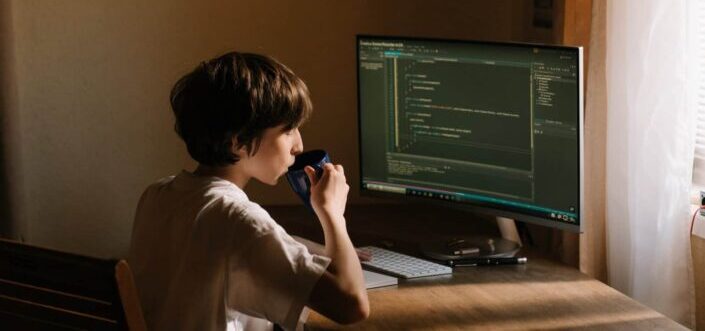 young boy coding on computer