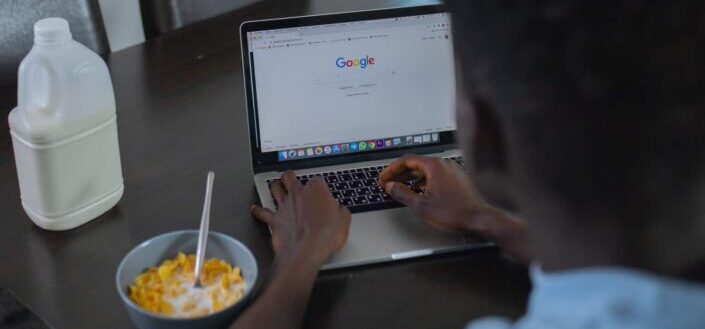 A man using laptop while eating