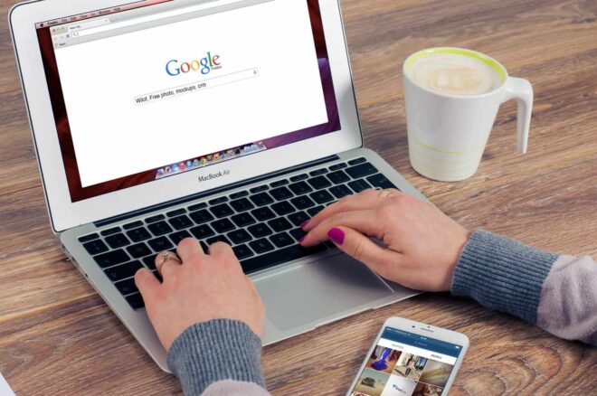 A woman typing and using Google - Google Tag Manager vs Google Analytics